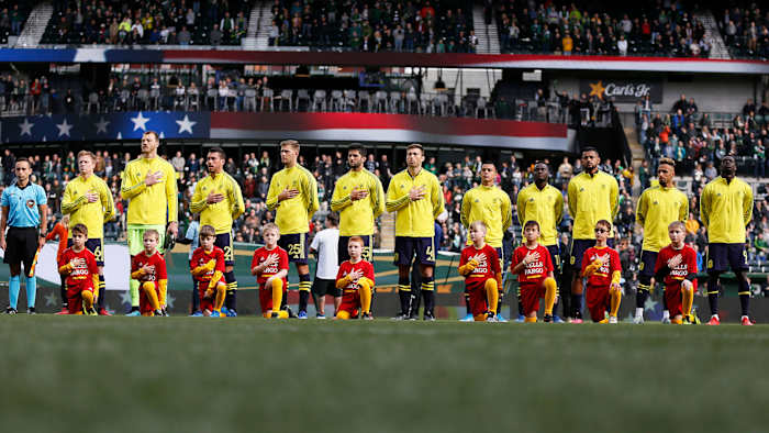 Nashville SC stands for the national anthem at an MLS game